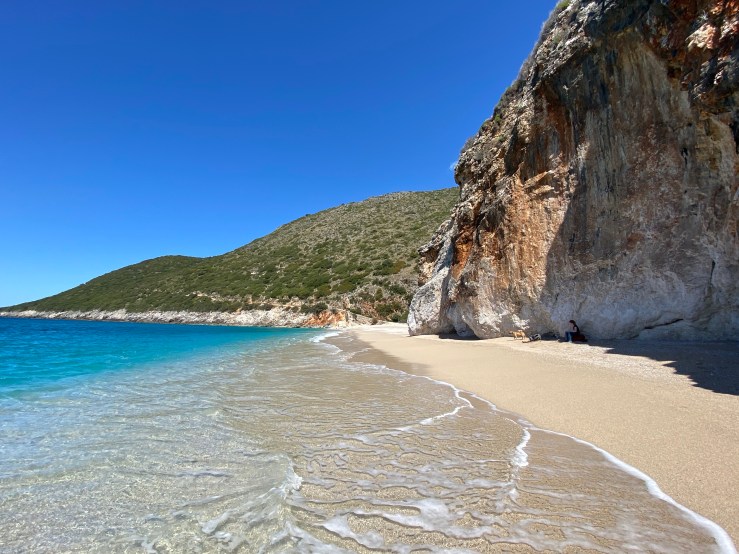 White sandy beaches with the clear sea lapping on it it. There is a crag right on Gjipe Beach. 