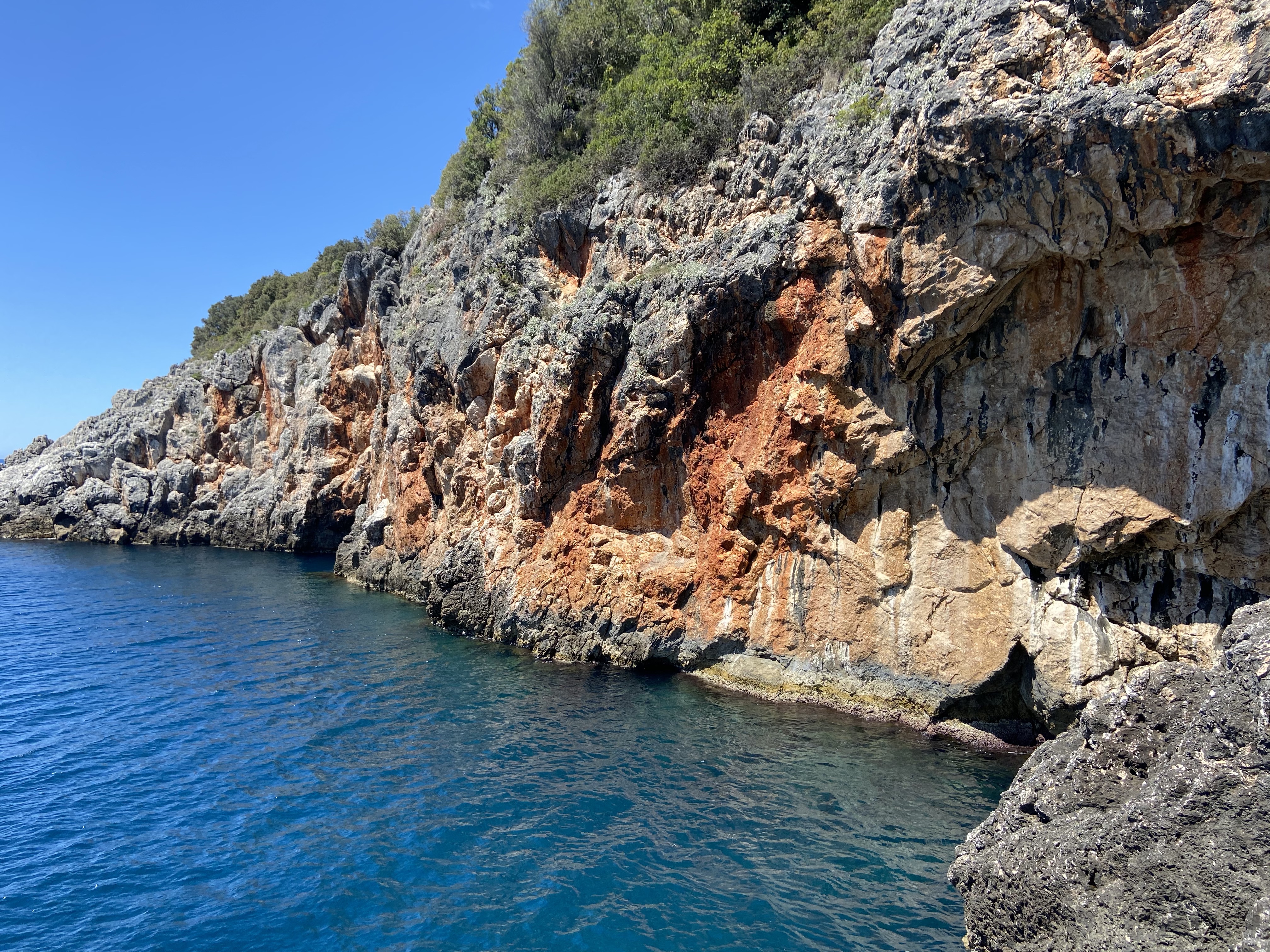 Small coastal crag with deep blue sea at the bottom.