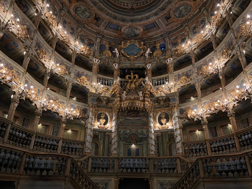 Grand opera house with ornate wooden carvings and several balconies.
