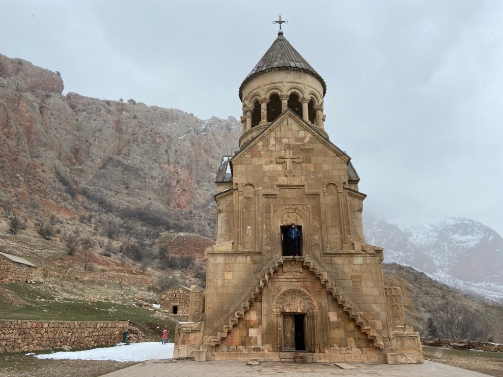 Person stood at the top of a symetrical staircase which is on the front of an orthodox church 