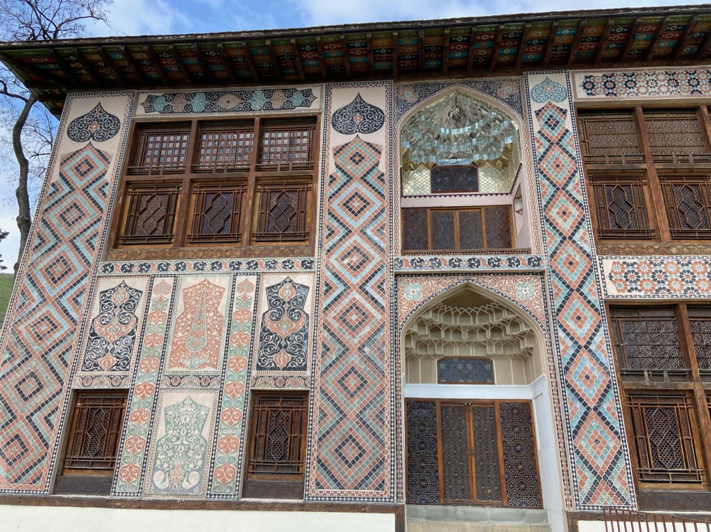 Elaborately decorated building with mirrored alcoves, and ornate stained glass windows in the local style of Sheki