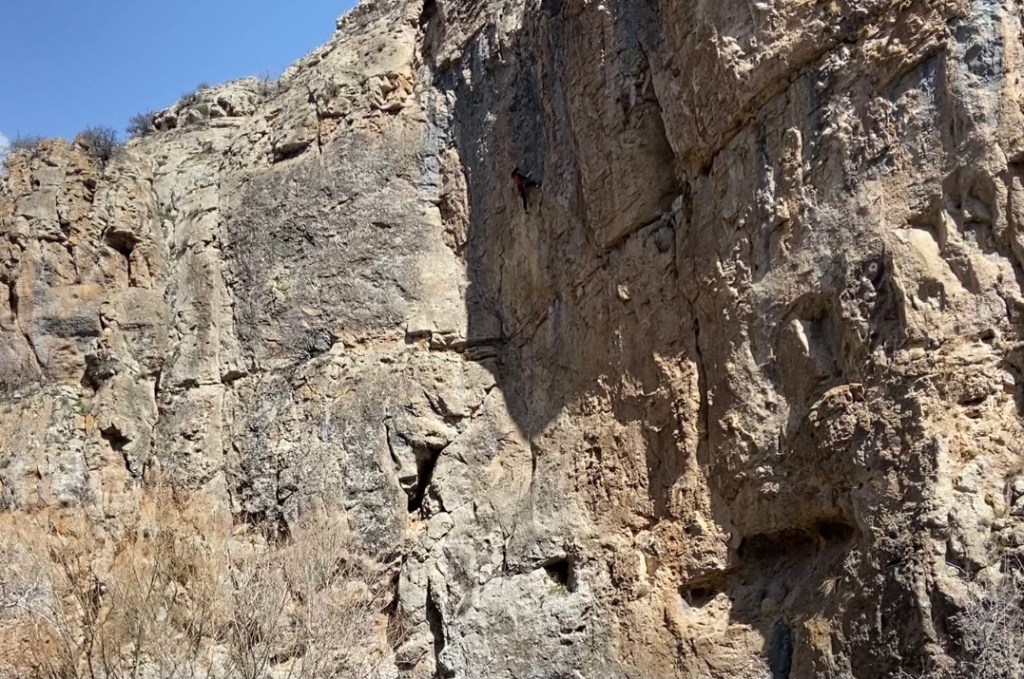 Climber on a route in the middle of a large wall