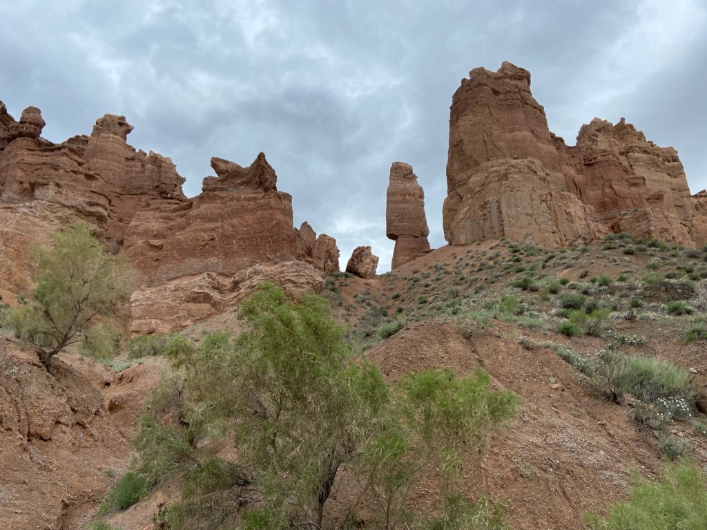 Interesting sandstone pillars and formations at the top of one side of the valley. Up to the formations there is desert like landscape with dust and bushes