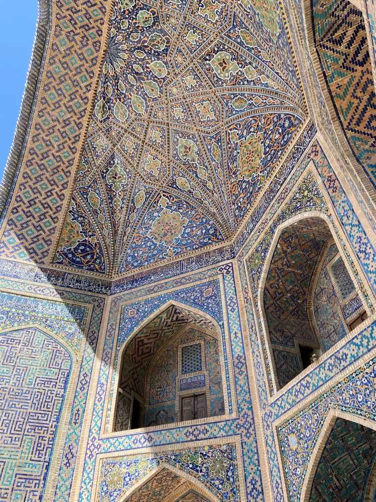 Looking up into the arch way which shows the finer detail of the patterns that the small shades of blue tiles form. Every surface of the building is tiled decoratively.