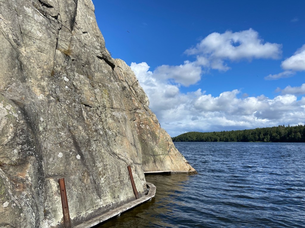 Wooden walk walk precariously over the water. The granite emerges out of the water.