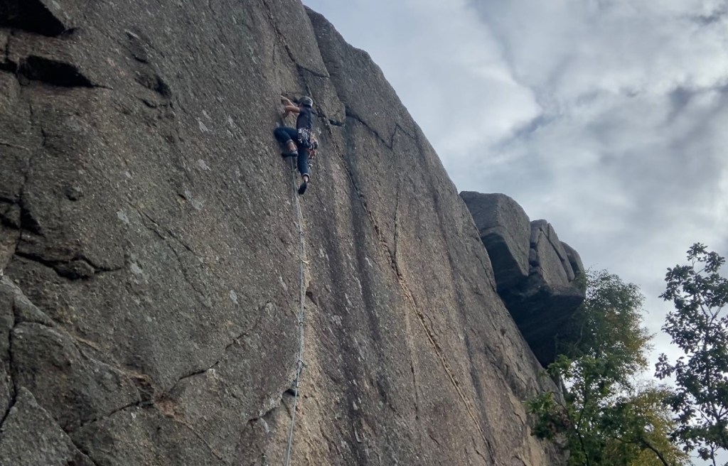 Climber jamming their hands up a crack in the granite rock