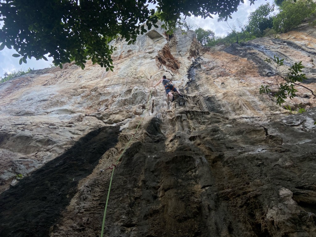 Climber using the tufas on the bottom of the wall with the face extending upwards