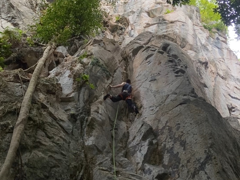 Climber bridging at the start of the crack which climber the corner where two walls meet at Bukit Takun.