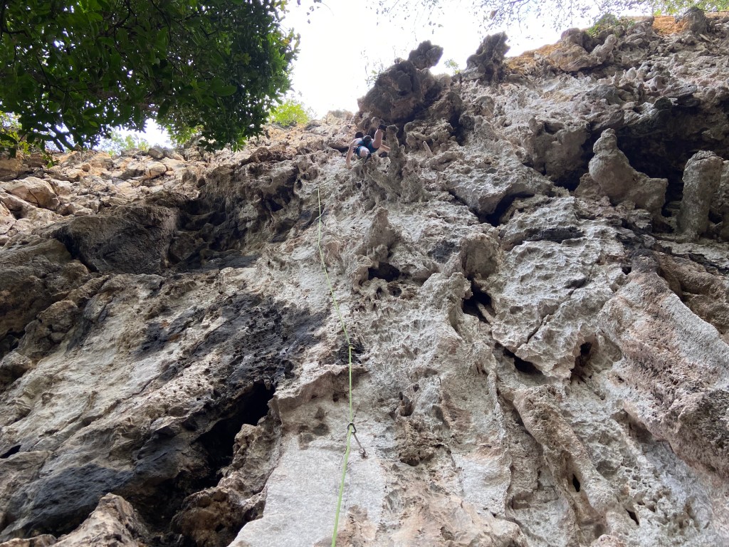 Climber on a 3D route on a tufa and heavily featured white limestone wall
