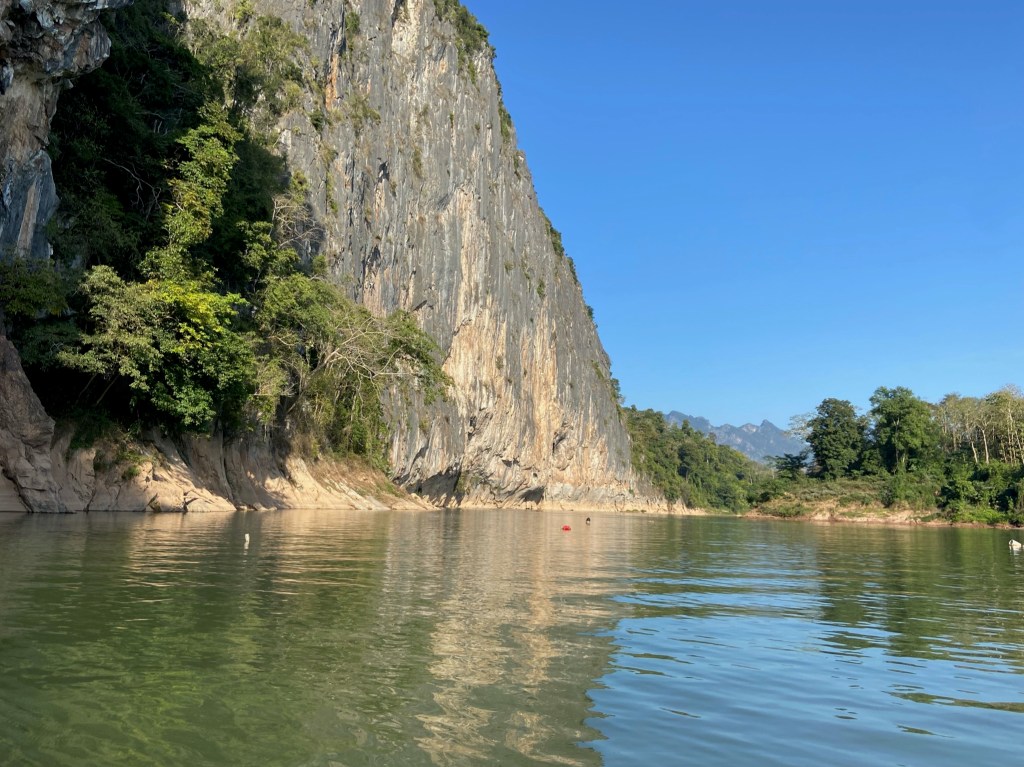 Grey and white limestone coming exploding straight out of the still river