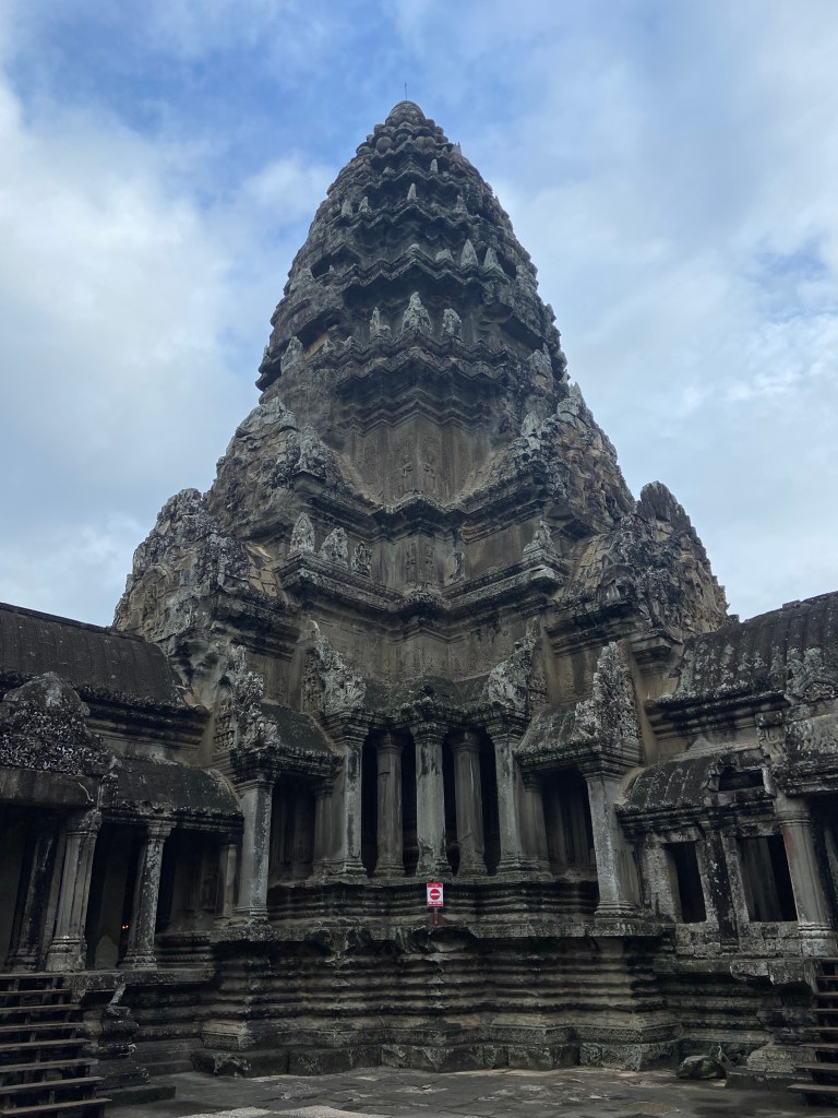 The central tower of the five iconic towers of Angkor Wat. The prasat (tower) is made from a dark sandstone and is a cone shape which has been ornately carved to resemble a lotus bud
