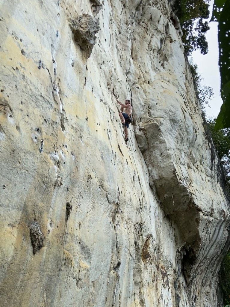 Climber on crossover hand move on the white, smooth limestone at Cantabaco. 