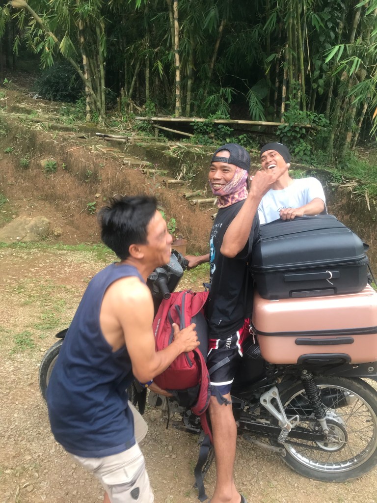 Three men laughing and joking about getting lost whilst transporting us and lots of luggage on motorbikes. 