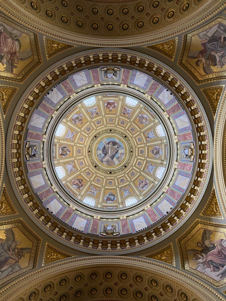 Magnificent dome ceiling of a cathedral, tiled and with catholic imagery. 