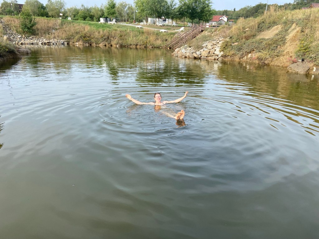 Woman floating on her back in salt bath with arms and feet in the air.