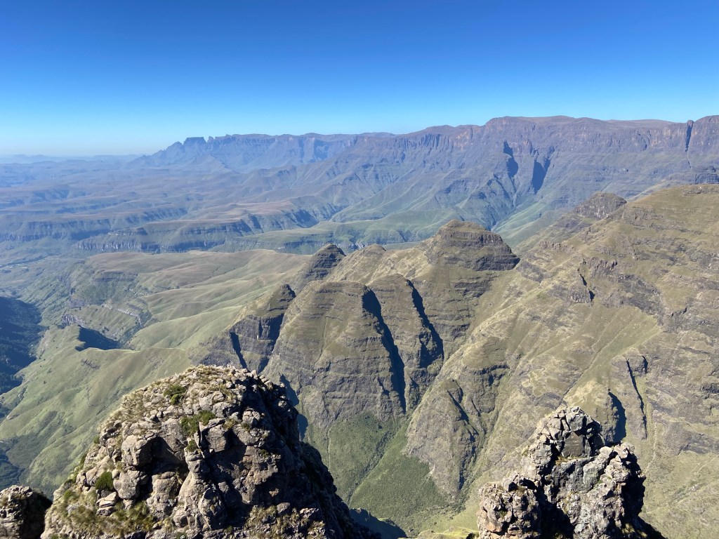 High plateau in the distance with steep sided mountains in the foreground. 