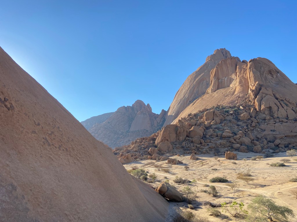 Large, golden granite domes with huge boulders scattered across the steep slopes. 