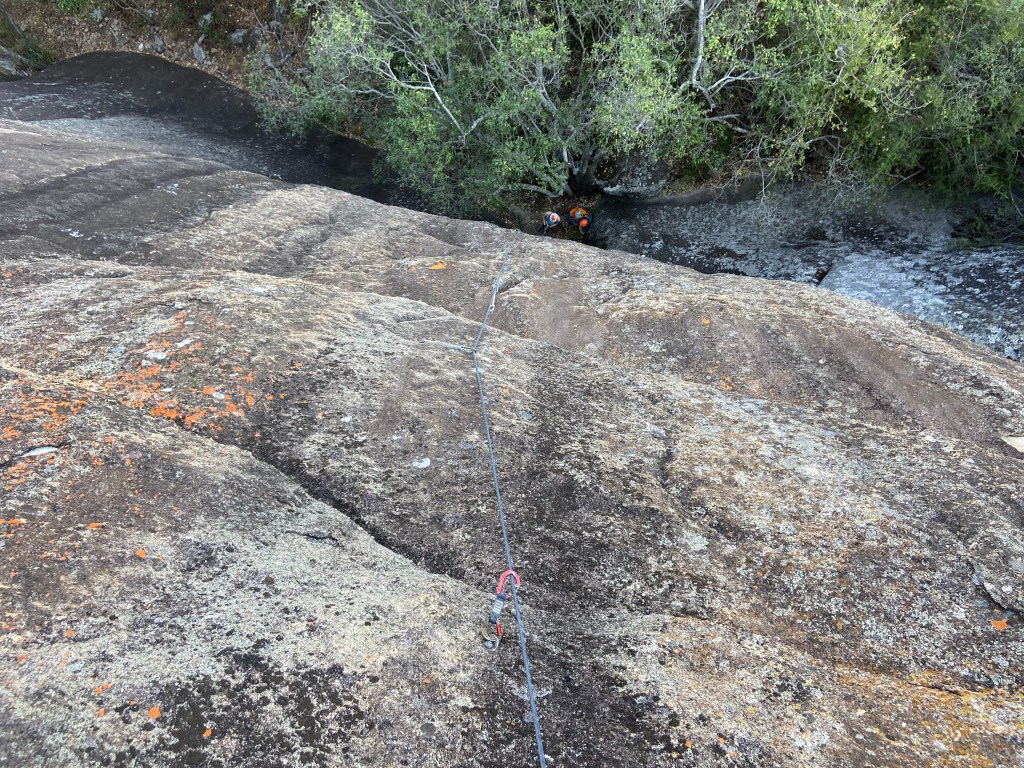 Looking down the smooth granite slab to the trees below. 