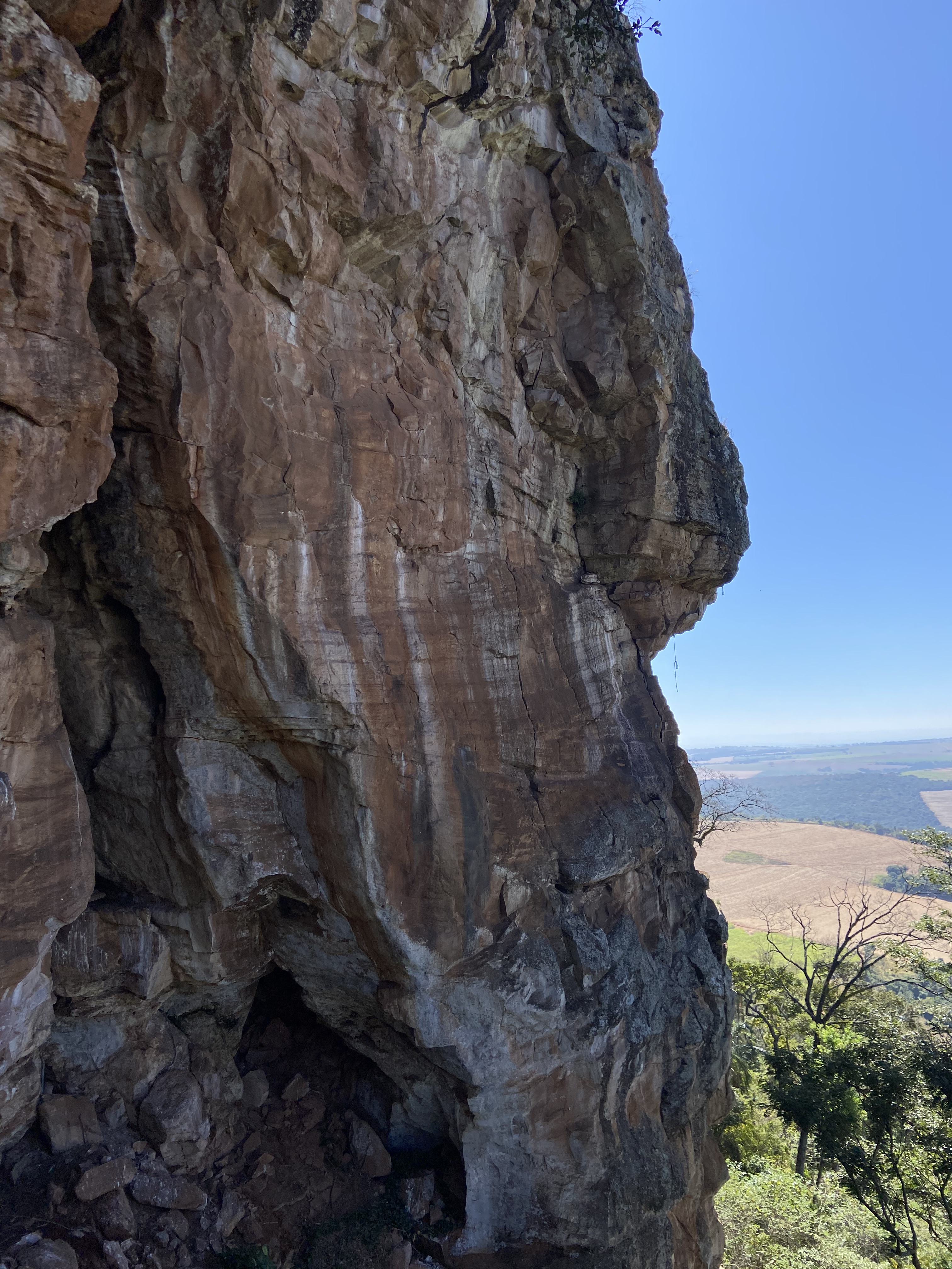 Tall, orange sandstone wall covered in white streaks.