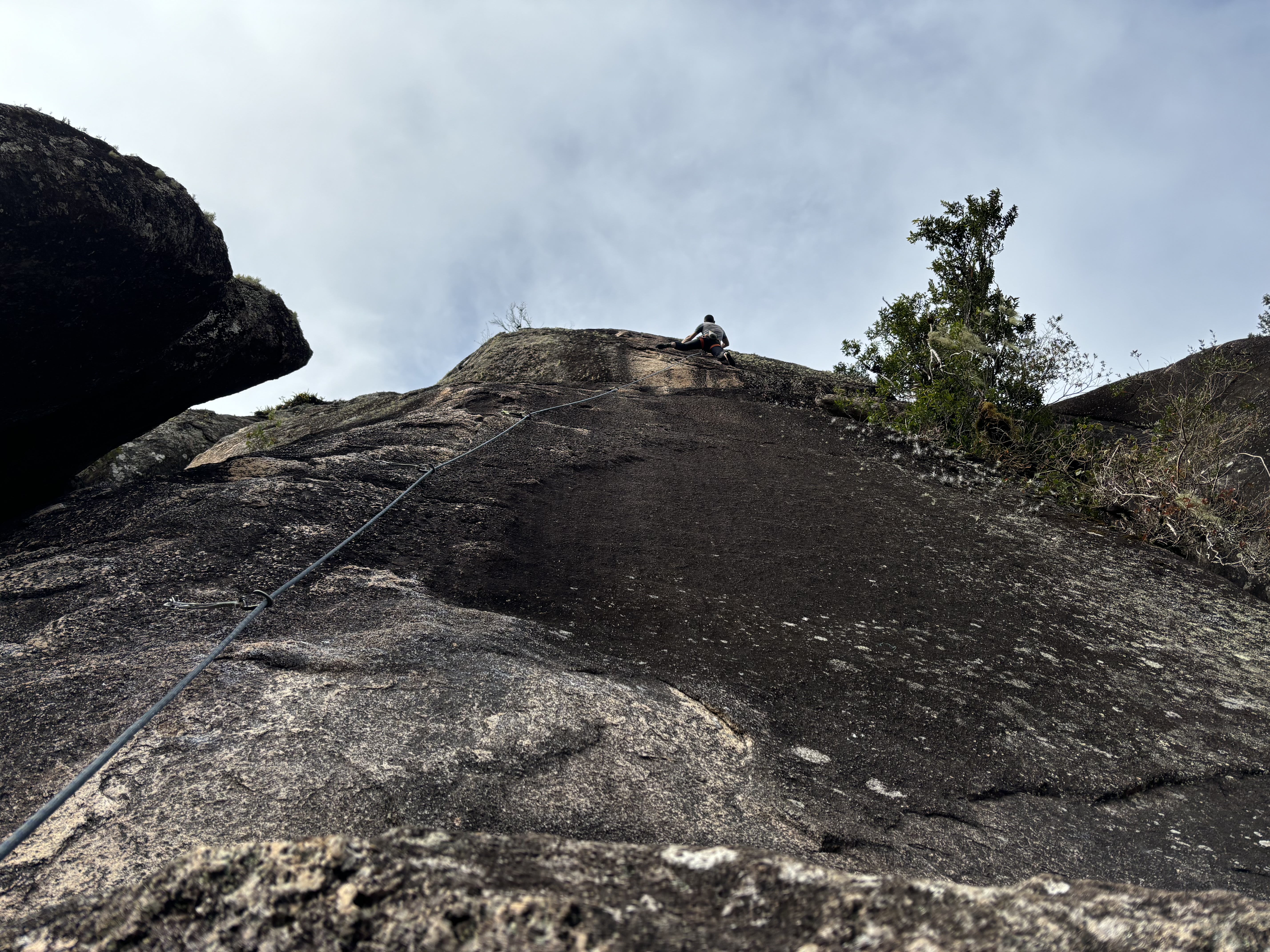 Climber balancing their way up a steep slab climb.
