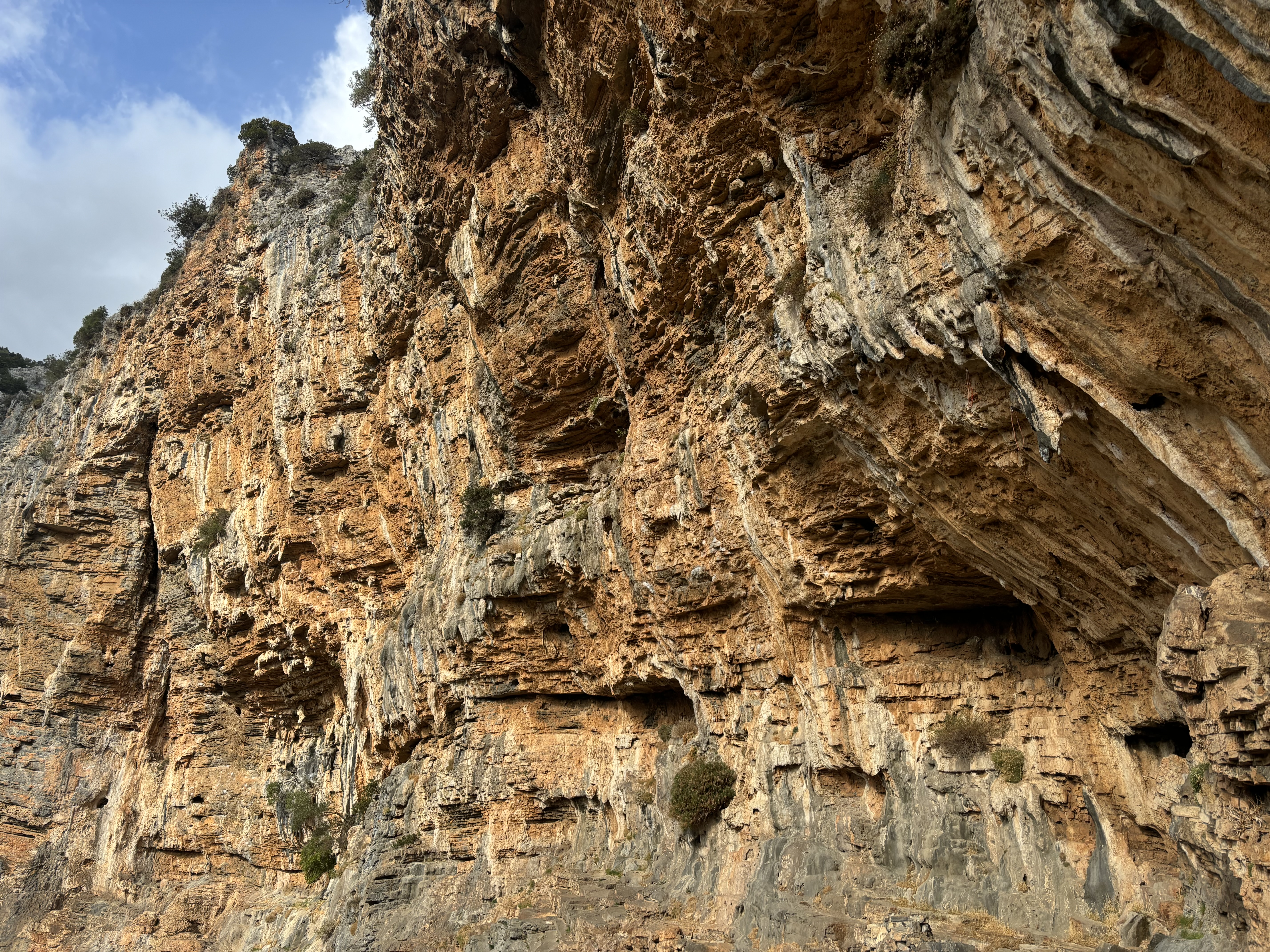 Orange, overhanging cave with tufas and stalactite features.